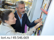 portrait of couple choosing books. Стоковое фото, агентство Ingram Publishing / Фотобанк Лори