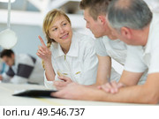 female in overalls asking question during training. Стоковое фото, агентство Ingram Publishing / Фотобанк Лори