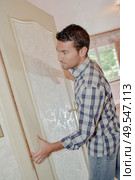 male worker is fitting a door. Стоковое фото, агентство Ingram Publishing / Фотобанк Лори