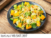 Vitamin spring salad with mango, cucumber and sprouts on old wooden table. Vegetable fruit salad with sprouts. Стоковое фото, агентство Ingram Publishing / Фотобанк Лори
