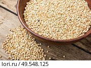 Uncooked green buckwheat on wooden background,vegan food.Dry buckwheat in white ceramic bowl. Green buckwheat on wooden table. Стоковое фото, агентство Ingram Publishing / Фотобанк Лори
