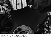 Minamalist black summer flat lay frame with hat and green leaves on plain background with copy space. Summer flat lay scenery. Стоковое фото, агентство Ingram Publishing / Фотобанк Лори