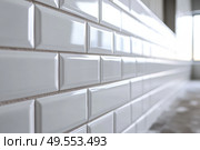 Ceramic tiles with a glossy finish and beveled edges set into horizontal brickwork. The sleek and clean wall design is ideal for kitchens and bathrooms with a minimalist or modern aesthetic. Banner. Стоковое AI-изображение, AI-художник Евгений Демидюк / Фотобанк Лори