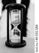 white sand hourglass in brown wood on table. Стоковое фото, агентство Ingram Publishing / Фотобанк Лори
