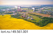 Panoramic aerial view of Belarus power plant with golden flowering field of rapeseed, canola or colza - two possibility for production of electric energy. Nuclear and traditional energy producing. Стоковое фото, агентство Ingram Publishing / Фотобанк Лори