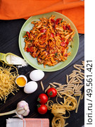  italian pasta with tomatos and herbs on dark wooden table. flat lay. Стоковое фото, агентство Ingram Publishing / Фотобанк Лори