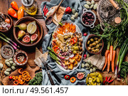 Tasty Mediterranean cuisine with healthy food with hummus plate. Ramadan iftar dinner. Various pickled and fresh  vegetables: olives, fids, green almond. Vegan party food Top view. Festive gathering. Стоковое фото, агентство Ingram Publishing / Фотобанк Лори