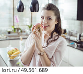 Pretty, young lady holding an apple. Стоковое фото, агентство Ingram Publishing / Фотобанк Лори
