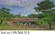 Himeji, Japan - Sep 24 2024, 4k, panoramic view of Sakuramon Bridge and entrance gate, with Himeji Castle, White Heron Castle on background, trees on foreground, at daytime, Himeji, Japan. Редакционное видео, видеограф Сергей Богомяко / Фотобанк Лори
