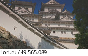 Himeji, Japan - Sep 24 2024, 4k, panoramic view of Himeji Castle, White Heron Castle from below, through tree foliage in daytime with blue sky and clouds, without people, Himeji, Japan. Стоковое видео, видеограф Сергей Богомяко / Фотобанк Лори