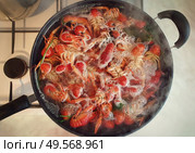 Cooking river crayfish, or crawfish, at home on a traditional recipe. A lot of red, freshwater lobsters boiling in a big bowl on hob. Preparing delicious, non gmo, organic food in house conditions. Стоковое фото, агентство Ingram Publishing / Фотобанк Лори