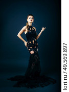 white girl modell on a dark background in a dress made of cut stripes of black fabric. Стоковое фото, агентство Ingram Publishing / Фотобанк Лори