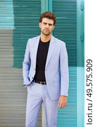 Attractive young man wearing suit standing outdoors.. Attractive man wearing suit standing in urban background. Стоковое фото, агентство Ingram Publishing / Фотобанк Лори
