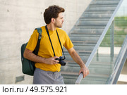Millennial man using a SLR camera outdoors. Millennial man taking photographs with a SLR camera. Стоковое фото, агентство Ingram Publishing / Фотобанк Лори