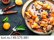 Baked pork in red wine with apricot in iron cast pan. Stew meat with apricot. Стоковое фото, агентство Ingram Publishing / Фотобанк Лори