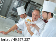 chef approving of trainees dessert creation. Стоковое фото, агентство Ingram Publishing / Фотобанк Лори