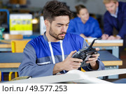 young engineer at desk with remote control aircraft. Стоковое фото, агентство Ingram Publishing / Фотобанк Лори