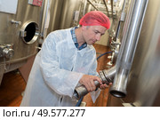 factory worker checking a metal vat. Стоковое фото, агентство Ingram Publishing / Фотобанк Лори