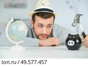 man observes sadly before breaking the piggy bank. Стоковое фото, агентство Ingram Publishing / Фотобанк Лори
