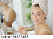 young woman plucking eyebrows with tweezers in front of mirror. Стоковое фото, агентство Ingram Publishing / Фотобанк Лори