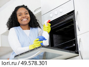 happy woman cleaning oven at home kitchen. Стоковое фото, агентство Ingram Publishing / Фотобанк Лори