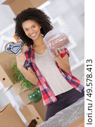 young girl moving in apartment packing and taping boxes. Стоковое фото, агентство Ingram Publishing / Фотобанк Лори