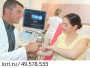 male doctor with female patient undergoing arm echography. Стоковое фото, агентство Ingram Publishing / Фотобанк Лори