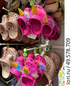 Belgrade, Serbia. August 03, 2024. A colorful display of Crocs-style shoes lines a store wall. The children shoes come in a variety of bright colors and styles. Редакционное фото, фотограф Ирина Старикова / Фотобанк Лори