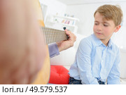 Child watching adult play guitar. Стоковое фото, агентство Ingram Publishing / Фотобанк Лори