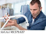 man putting together clothe rack. Стоковое фото, агентство Ingram Publishing / Фотобанк Лори