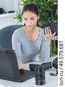 female photographer sitting on the desk with laptop. Стоковое фото, агентство Ingram Publishing / Фотобанк Лори