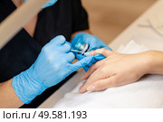 Close-up of Beautician painting her client’s nails in blue and yellow nail varnish in a beauty centre. Close-up of Beautician painting her client’s nails in blue and yellow nail varnish. Стоковое фото, агентство Ingram Publishing / Фотобанк Лори