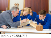 woodworking apprentice observing making of practical furniture. Стоковое фото, агентство Ingram Publishing / Фотобанк Лори