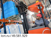 a warehouse worker driving forklift. Стоковое фото, агентство Ingram Publishing / Фотобанк Лори