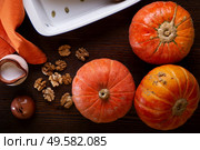ripe orange pumkins served at wooden brown table with  walnuts and coconut milk.  top view. healthy life concept. Стоковое фото, агентство Ingram Publishing / Фотобанк Лори