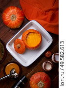 baked pumpkin cream coup served in pumpkin. served at wooden brown table with ripe orange  pumkins. flat lay. healthy life concept. Стоковое фото, агентство Ingram Publishing / Фотобанк Лори
