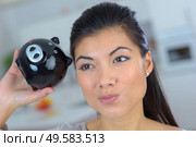 closeup of woman shaking piggybank dubious expression. Стоковое фото, агентство Ingram Publishing / Фотобанк Лори