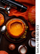 baked pumpkin cream coup with corn served in pumpkin with coconut and dairy creams . served at wooden brown table with ripe orange  pumkins. flat lay. healthy life concept. Стоковое фото, агентство Ingram Publishing / Фотобанк Лори