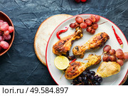 Baked chicken legs with grapes.Roasted chicken legs on plate. Barbecued chicken drumsticks. Стоковое фото, агентство Ingram Publishing / Фотобанк Лори