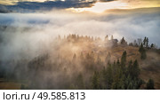 Alpine village. Autumn rural landscape. Cold November morning. Morning fog in mountain valley. Forest covered by low clouds. Misty fall woodland. Picturesque resort Carpathians range, Ukraine, Europe. Стоковое фото, агентство Ingram Publishing / Фотобанк Лори