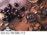 art background with healthy delicious dark truffles, chocolate  and  ingridients:  natural cocoa beans,  powder, chocolate, almonds  nuts and  ripe cherry. healthy sweets concept. flat lay. Стоковое фото, агентство Ingram Publishing / Фотобанк Лори