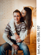 a guy and a girl celebrate the new year togetherin a warm atmosphere and give each other gifts. Стоковое фото, агентство Ingram Publishing / Фотобанк Лори