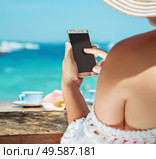 Relaxed woman using a smartphone on a tropical beach. Стоковое фото, агентство Ingram Publishing / Фотобанк Лори