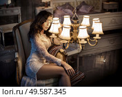 Elegant, young woman holding an antique chandelier. Стоковое фото, агентство Ingram Publishing / Фотобанк Лори