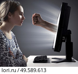 Pretty woman looking at the monitor - Internet violence symbol. Стоковое фото, агентство Ingram Publishing / Фотобанк Лори