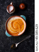 baked pumpkin cream coup with  coconut milk served in nice bowl at wooden black table. flat lay. cooking and healthy life concept. Стоковое фото, агентство Ingram Publishing / Фотобанк Лори