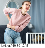 Woman suffering from lower back pain at home. Стоковое фото, фотограф Яков Филимонов / Фотобанк Лори