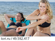gorgeous blonde in bikini applying suncream on the beach. Стоковое фото, агентство Ingram Publishing / Фотобанк Лори
