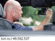 confident man looking into the rearview mirror. Стоковое фото, агентство Ingram Publishing / Фотобанк Лори