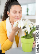 woman smells the flowers at home. Стоковое фото, агентство Ingram Publishing / Фотобанк Лори